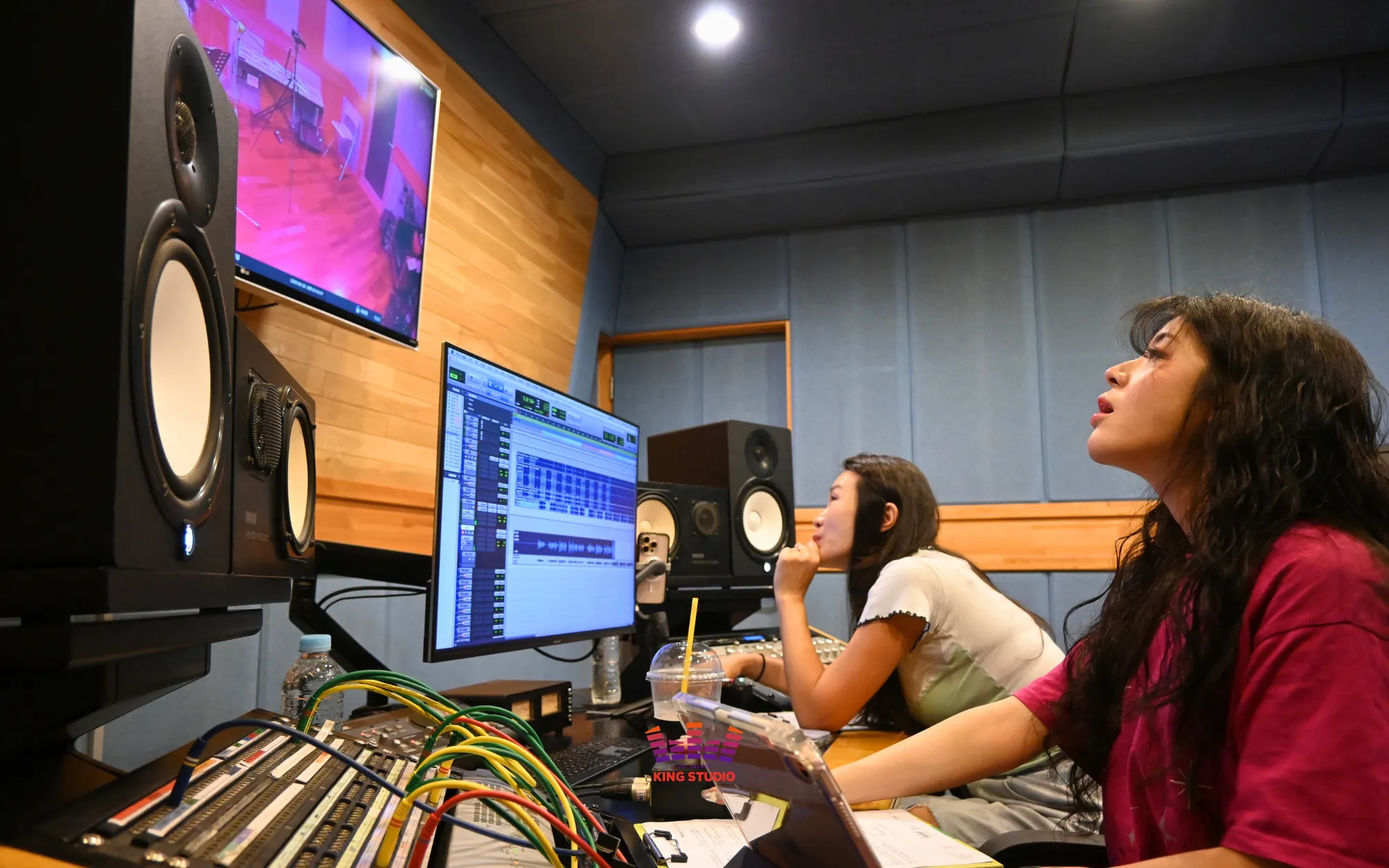 Vocal director giving live directing through the booth glass during the 90-minute session